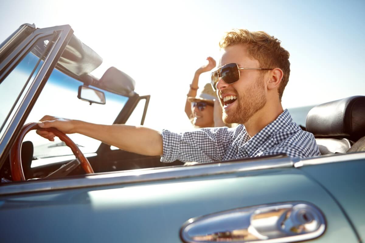 Foto eines Cabrios mit zwei Personen für das Thema: Wie alt muss man sein, wenn man ein Auto mieten möchte?